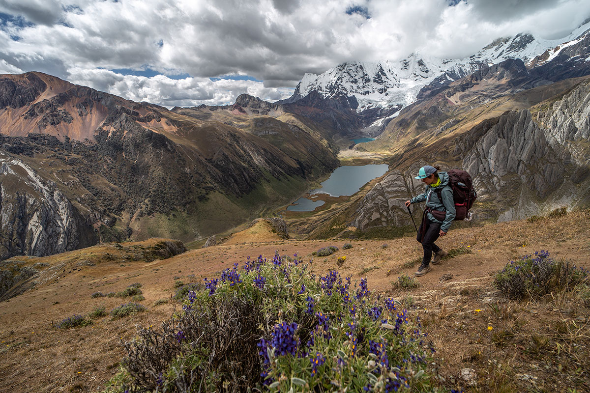 ​​A woman hikes down a slope in the Scarpa Rush TRK GTX hiking boot