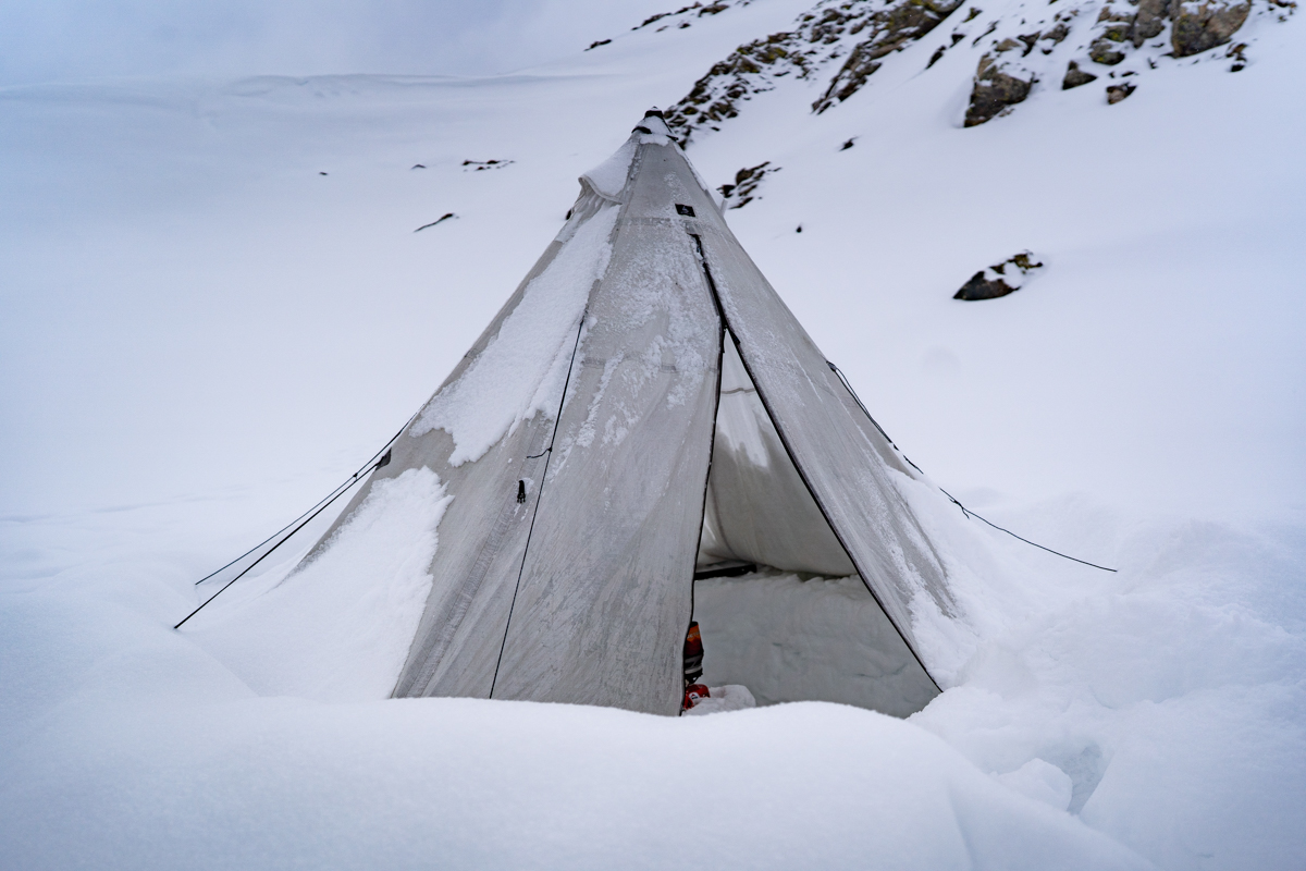 A pyramid tent pitched in deep snow