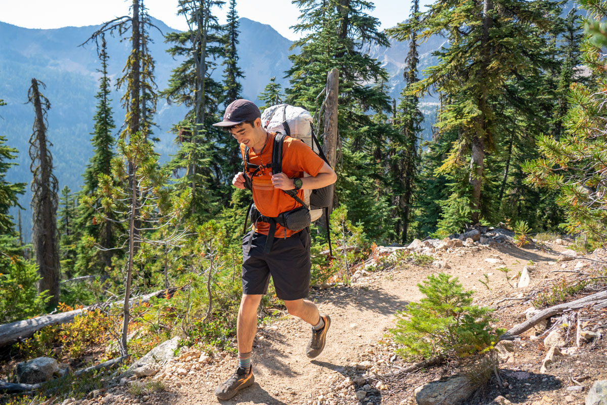 A man hiking in the forest wearing a GPS watch