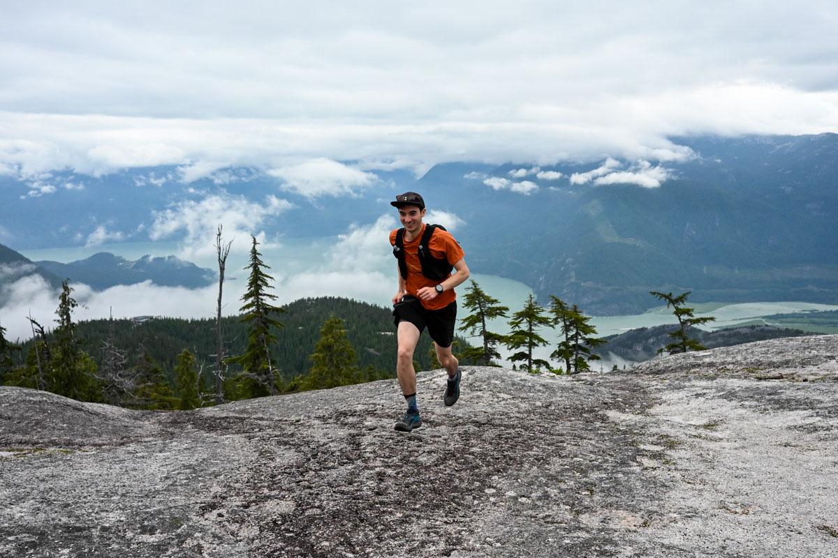 A man running in the alpine wearing a GPS watch