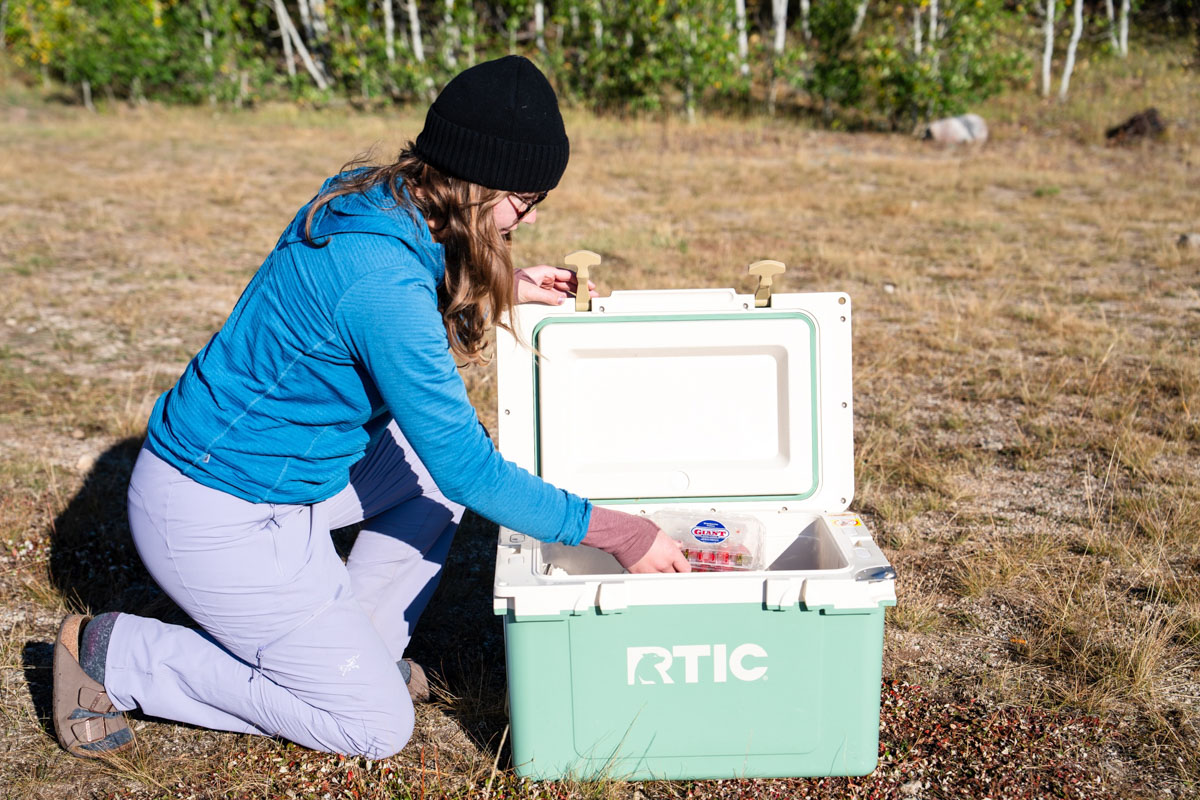 A woman pulling food out of a cooler