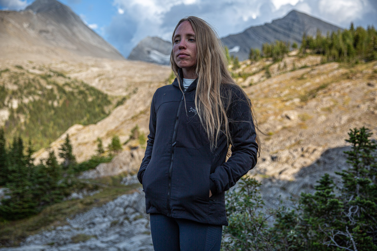 A woman standing in the mountains wearing a synthetic jacket