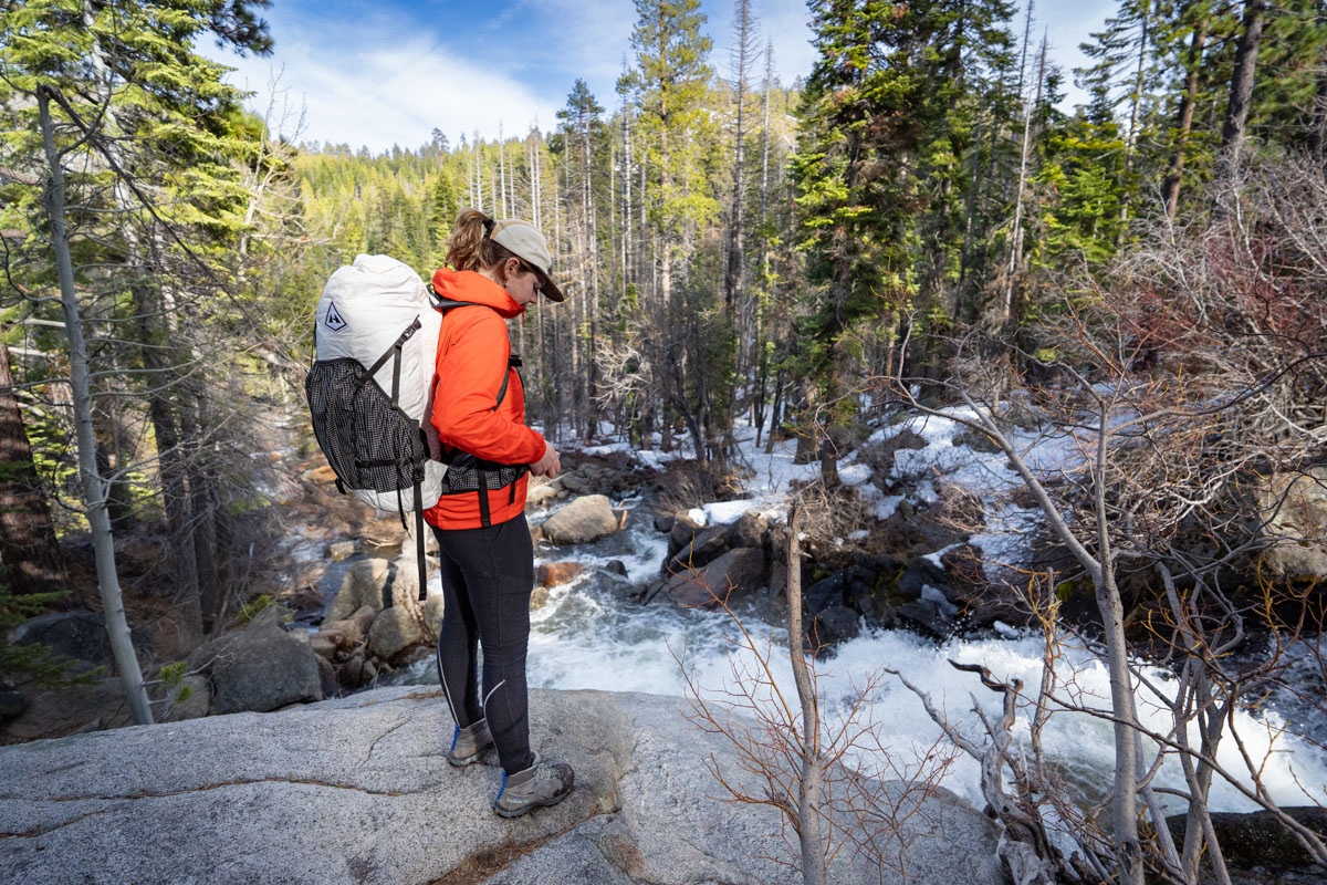 A woman standing on a rock wearing a synthetic jacket