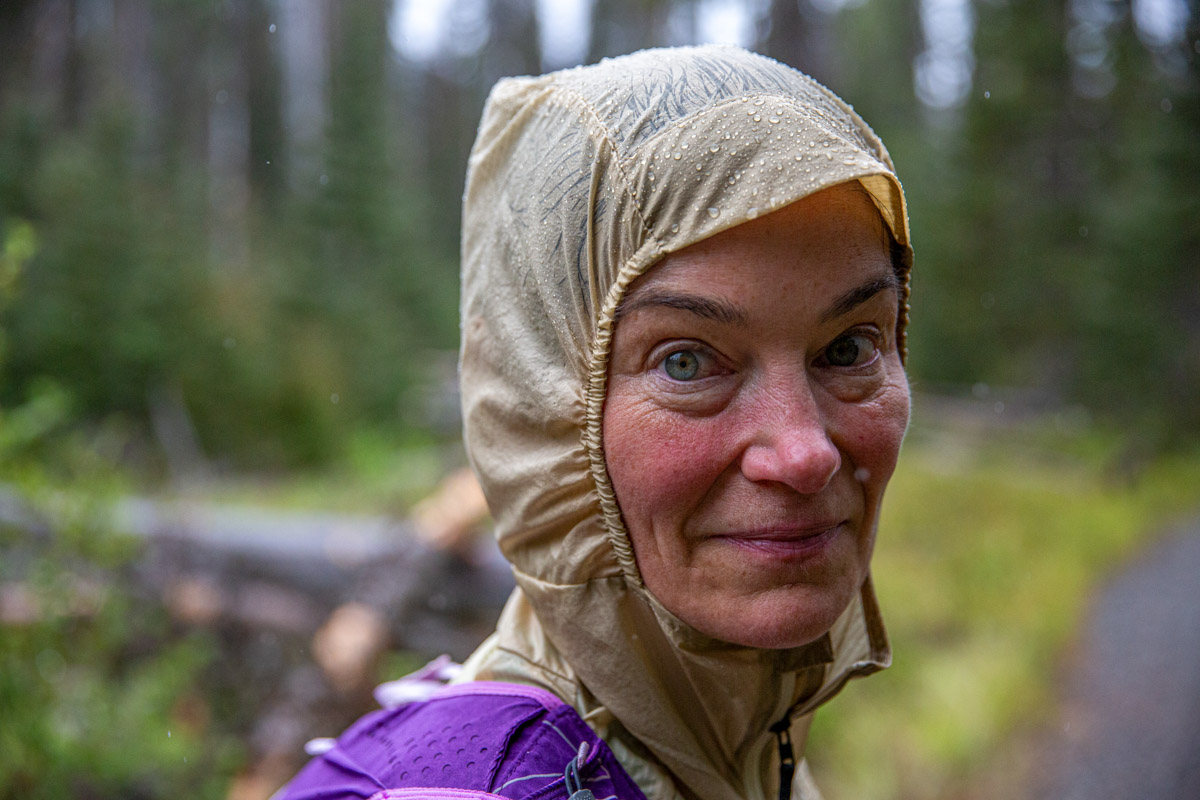 A woman with a windbreaker hood on her head