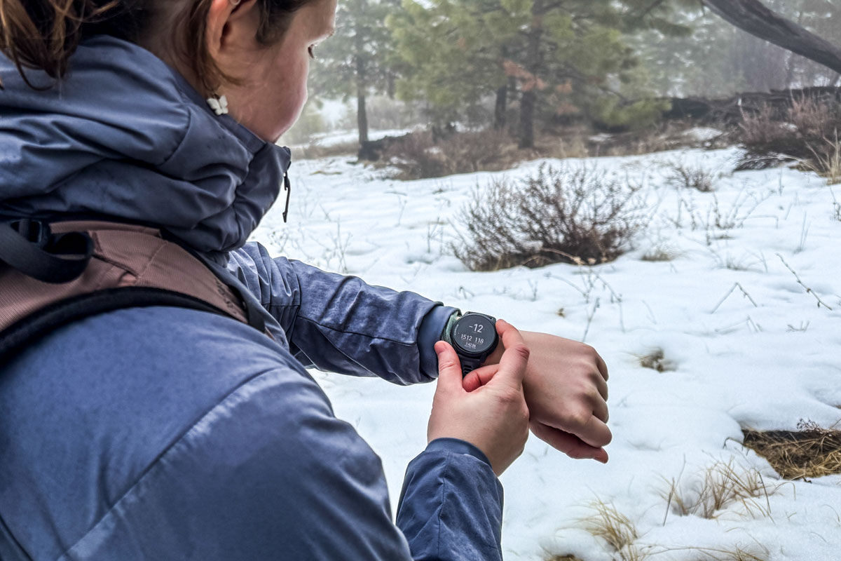 Adjusting a GPS watch on a snowy hike