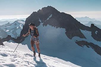 A mountain runner ascends a glacier while running.