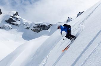 A backcountry skier coming down a steep slope