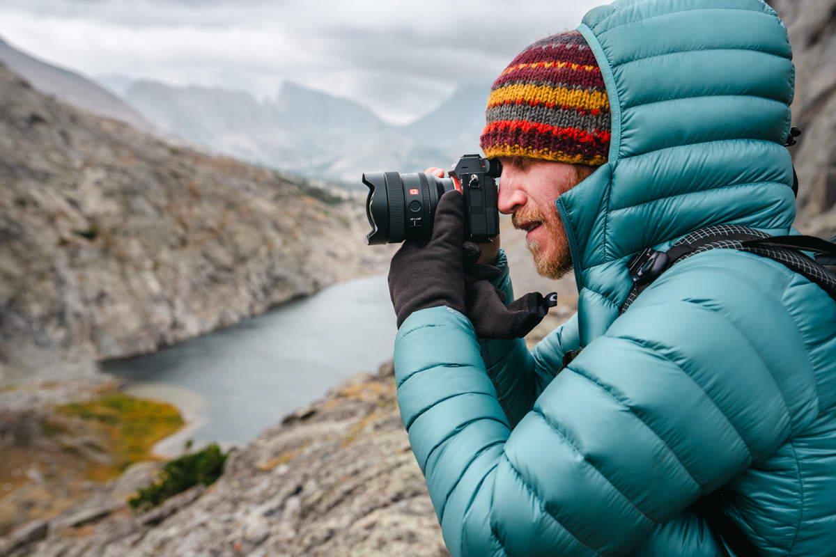 A man taking a photo of a lake