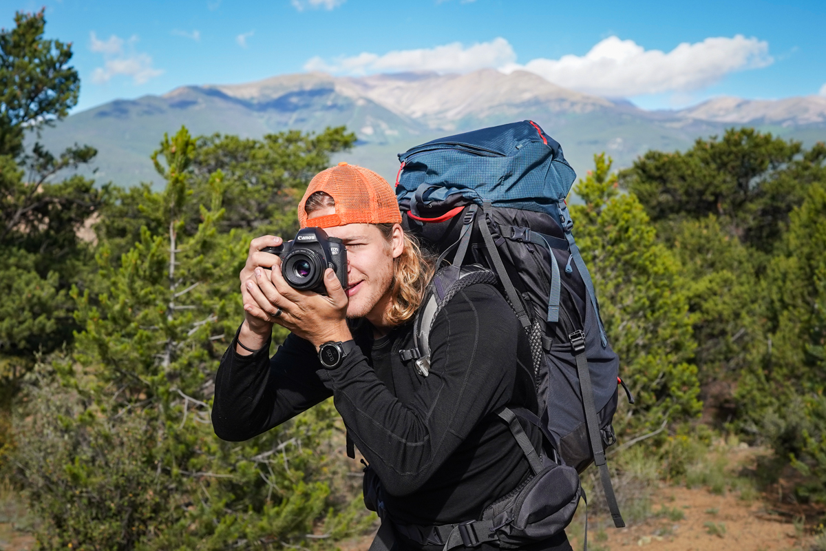 A man taking a photo while backpacking