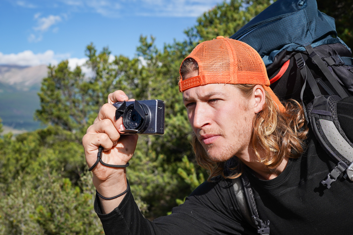 A man taking a photo with a Ricoh GR