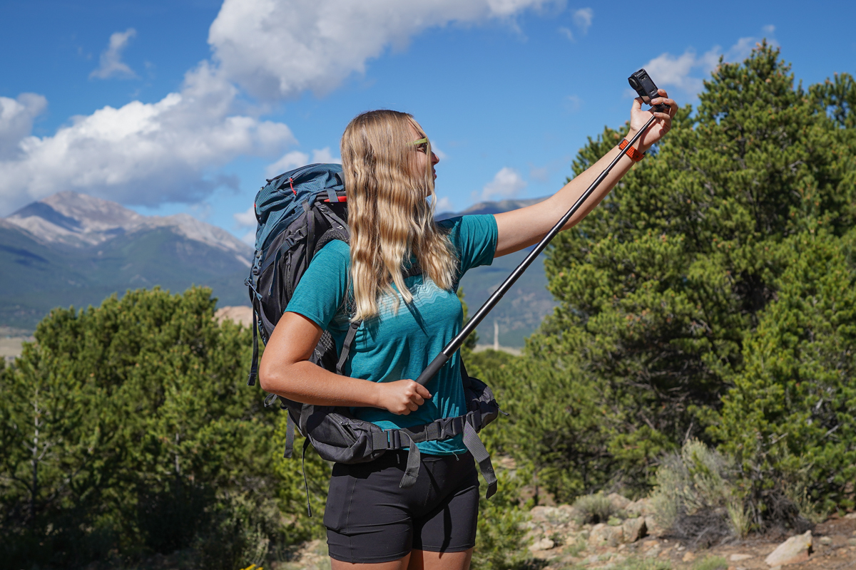 A woman takes a selfie with an action camera