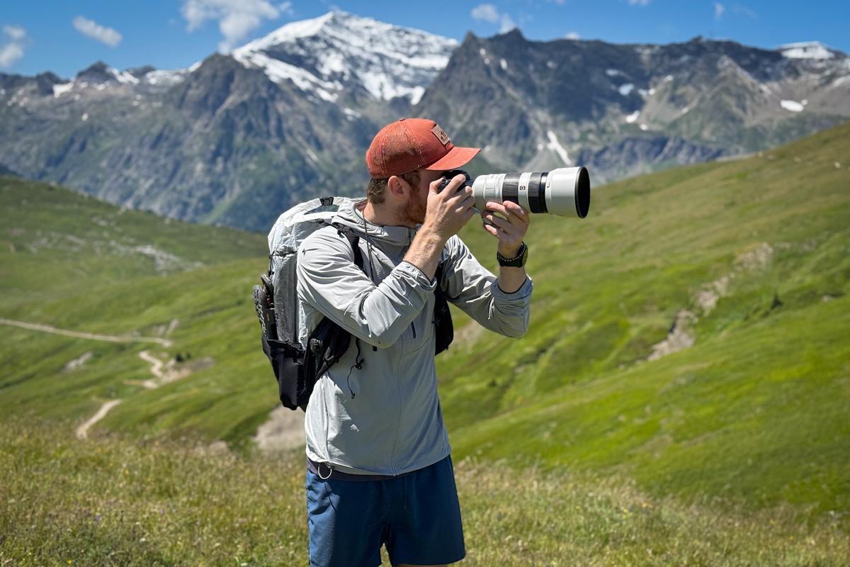 A man hiking in Switzerland with a telephoto lens