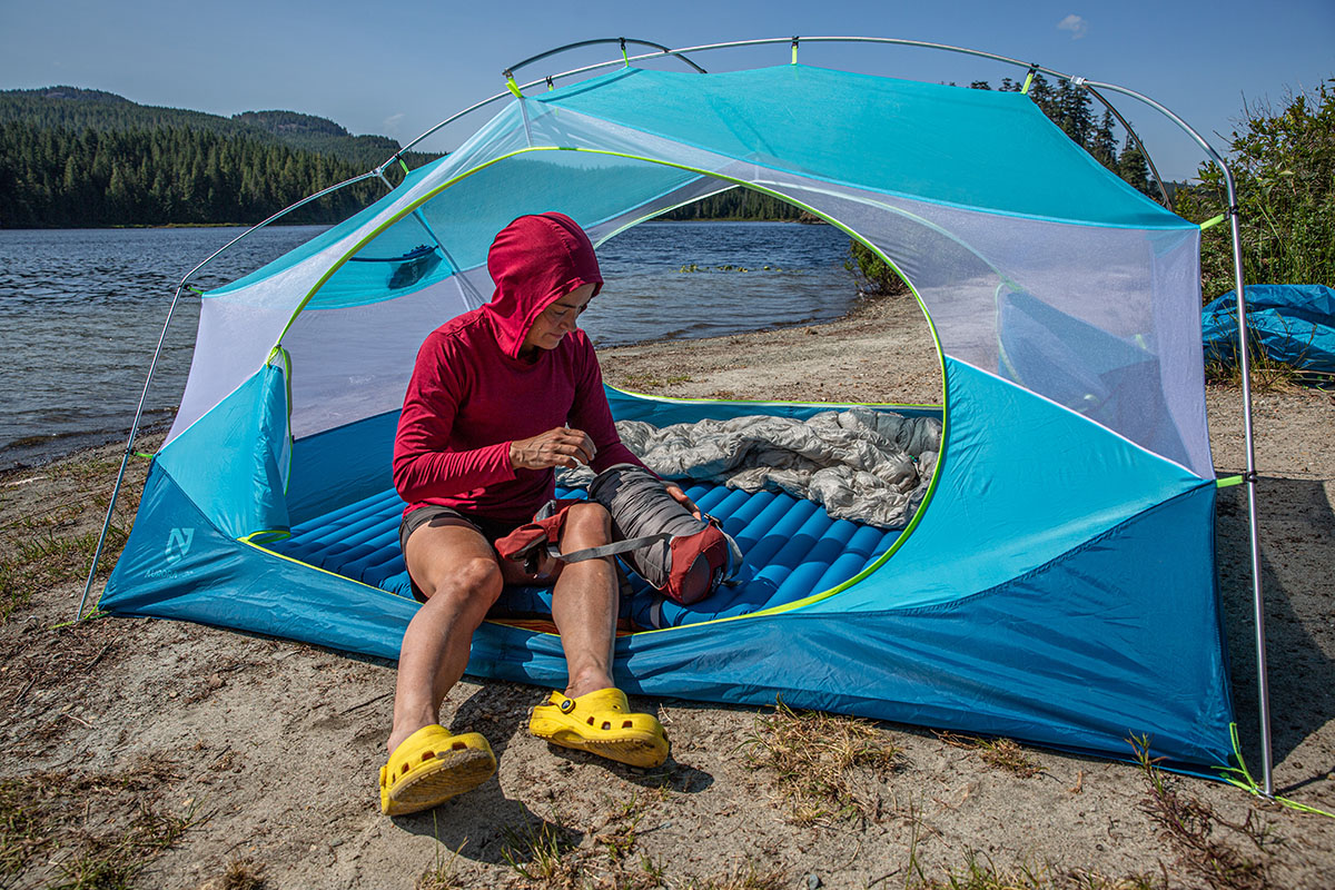 A woman setting up camp in camp shoes