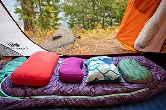 Camping and backpacking pillows lined up on a sleeping bag