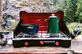 The Camp Chef Everest 2X stove set up on a picnic table