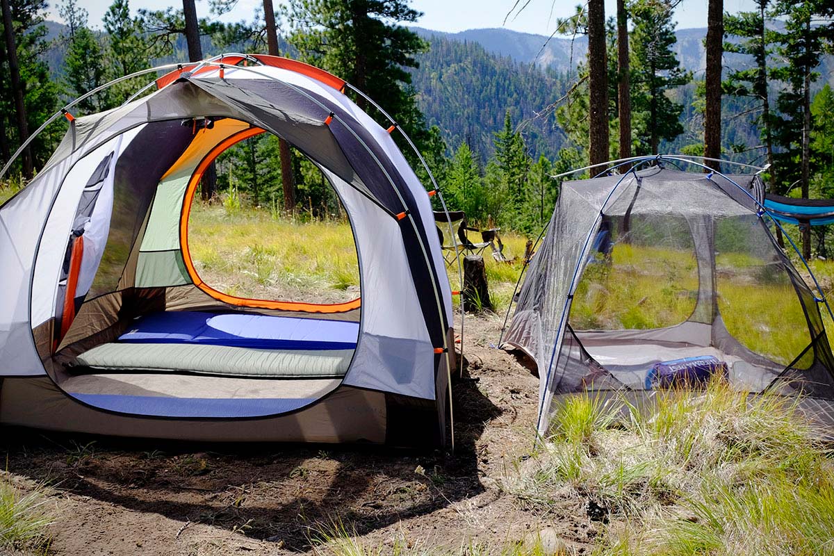 Two tents pictured side-by-side, one a large car camping tent, the other a smaller backpacking tent.
