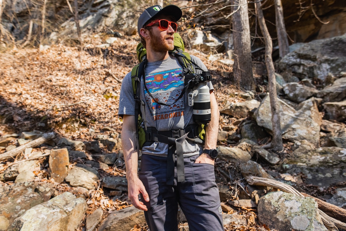 A man carrying a heavy camera while backpacking