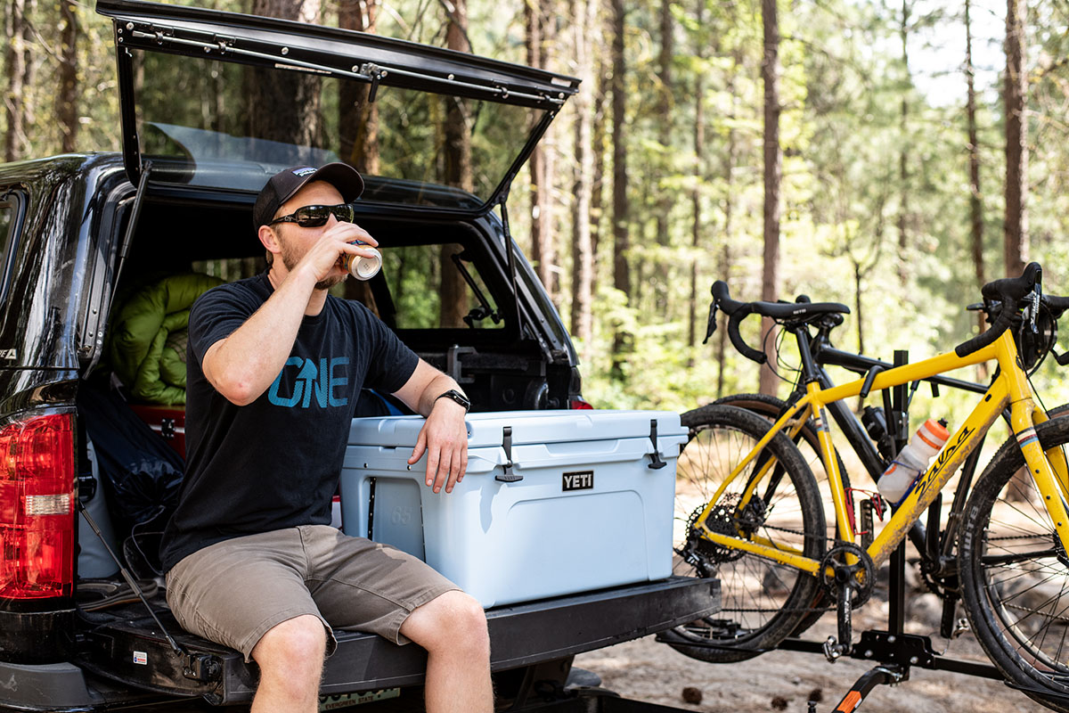 A man sits on a tailgate next to the Yeti Tundra.