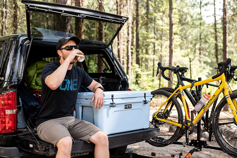 A man sits on a tailgate next to the Yeti Tundra
