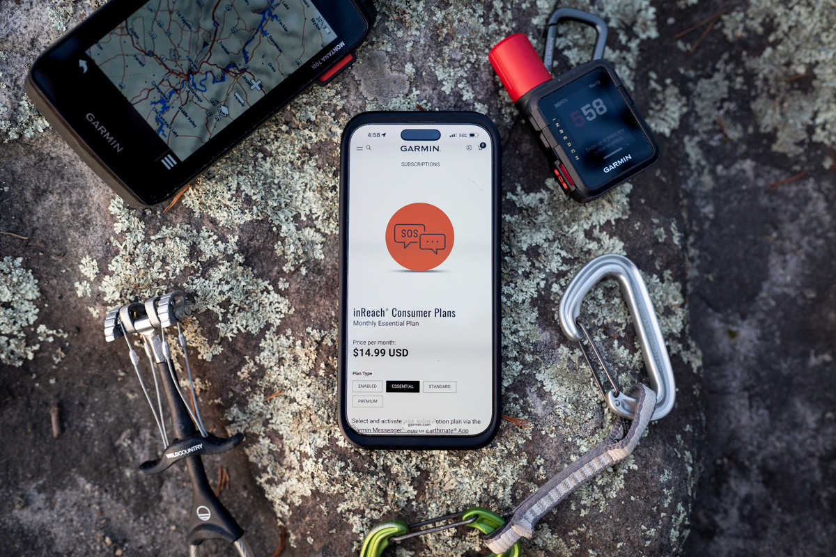 Two Garmin devices and a smartphone shown on a rock