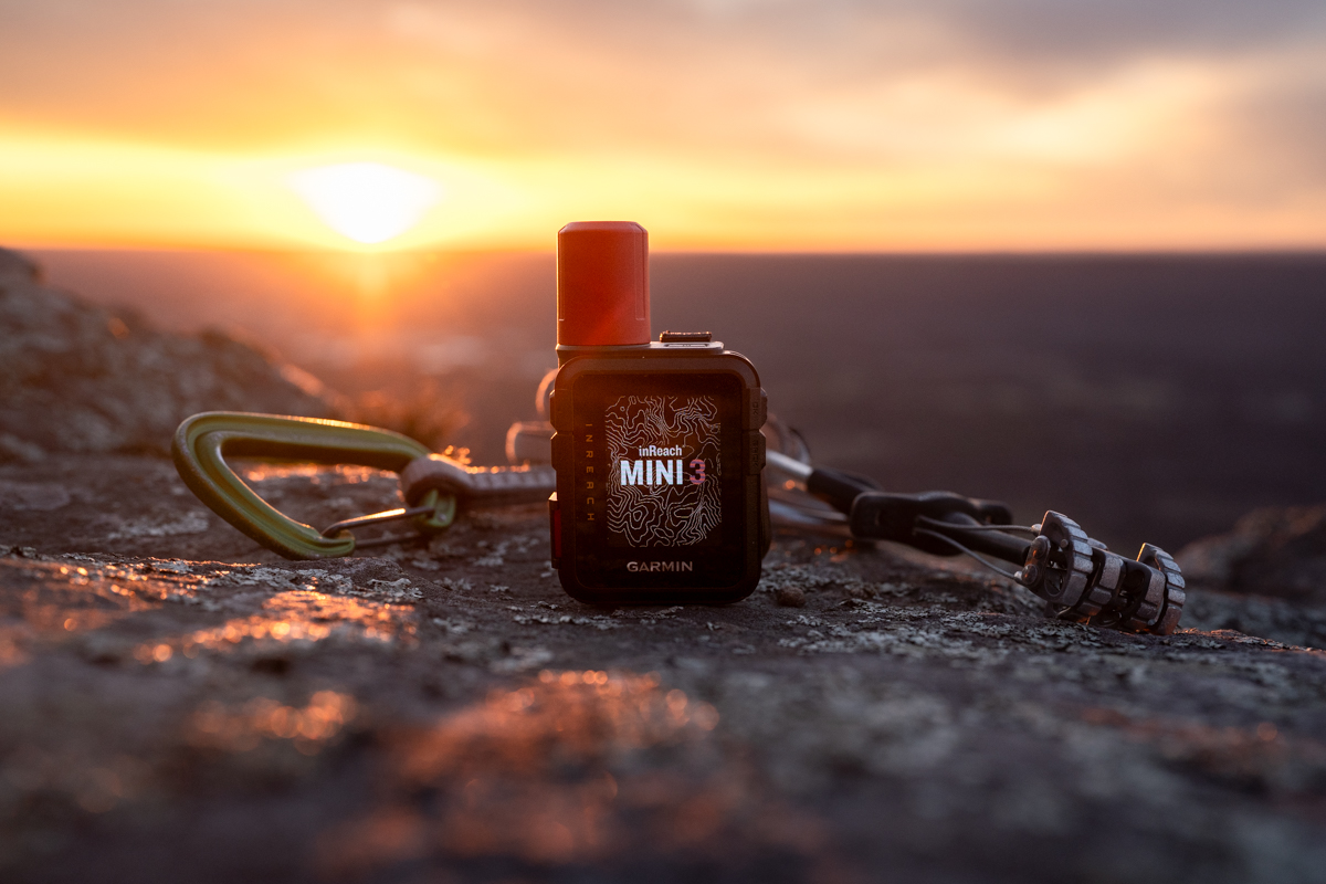 An inReach Mini 3 on a rock in the sunset