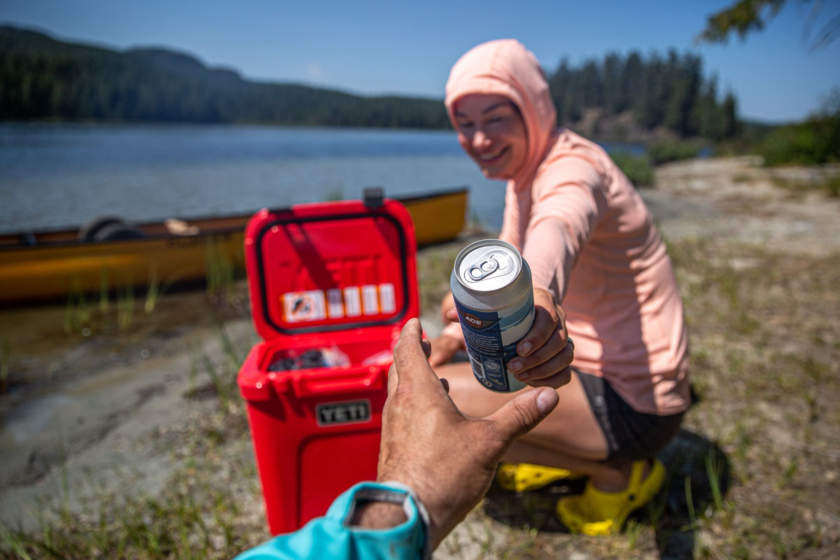 Handing a drink with a cooler in the background