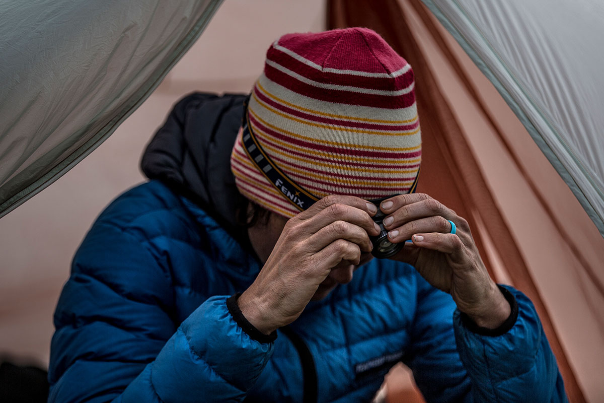 A woman adjusting the strap of a headlamp