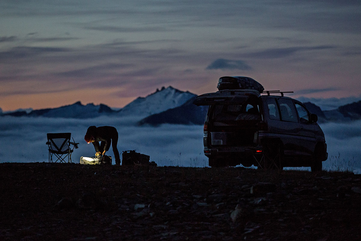 Someone using a headlamp near a large van