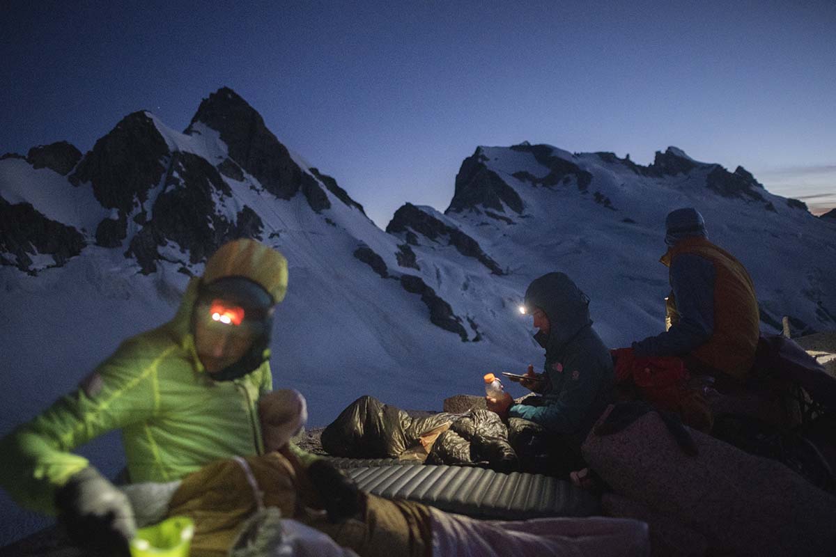 Campers using headlamps near mountains