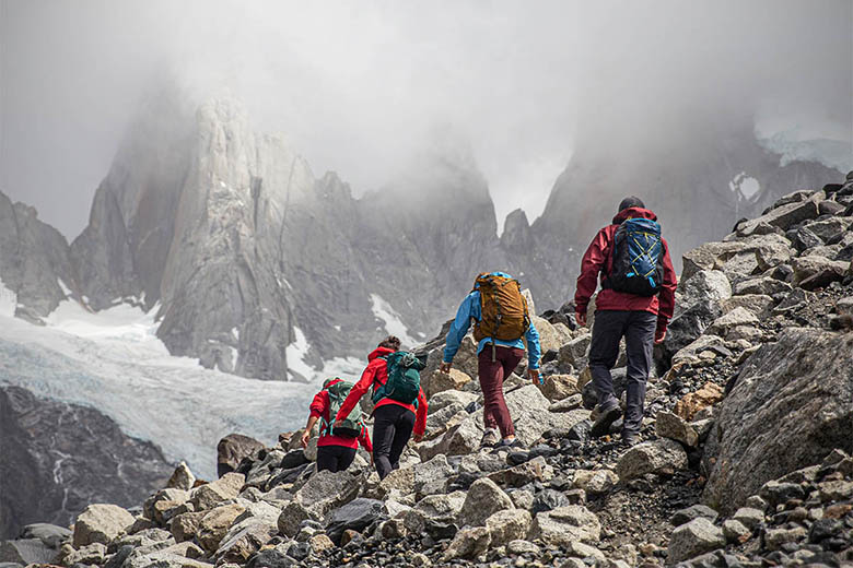 A group of hikers trek into foggy mountain peaks