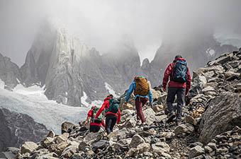A group of hikers trek into foggy mountain peaks