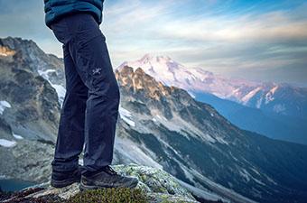 A hiker looks over a vast mountain canyon.