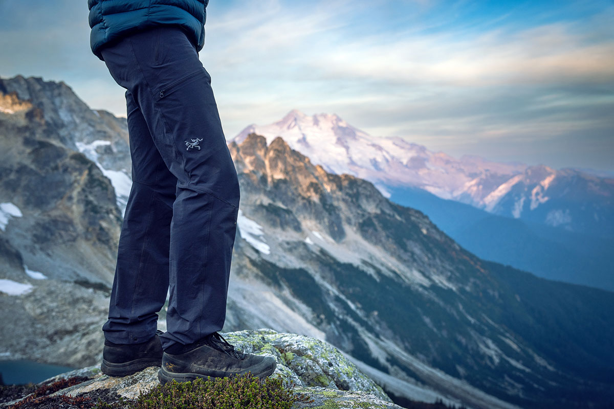 A hiker looks over a vast mountain canyon.