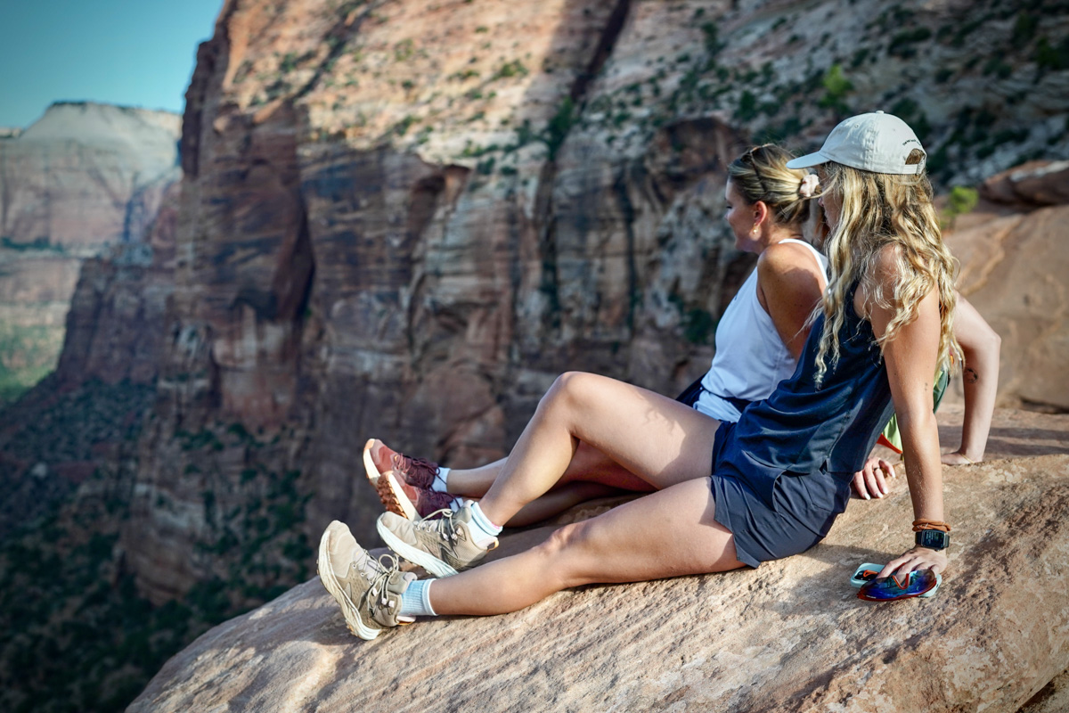 Two women sit at an overlook in Zion