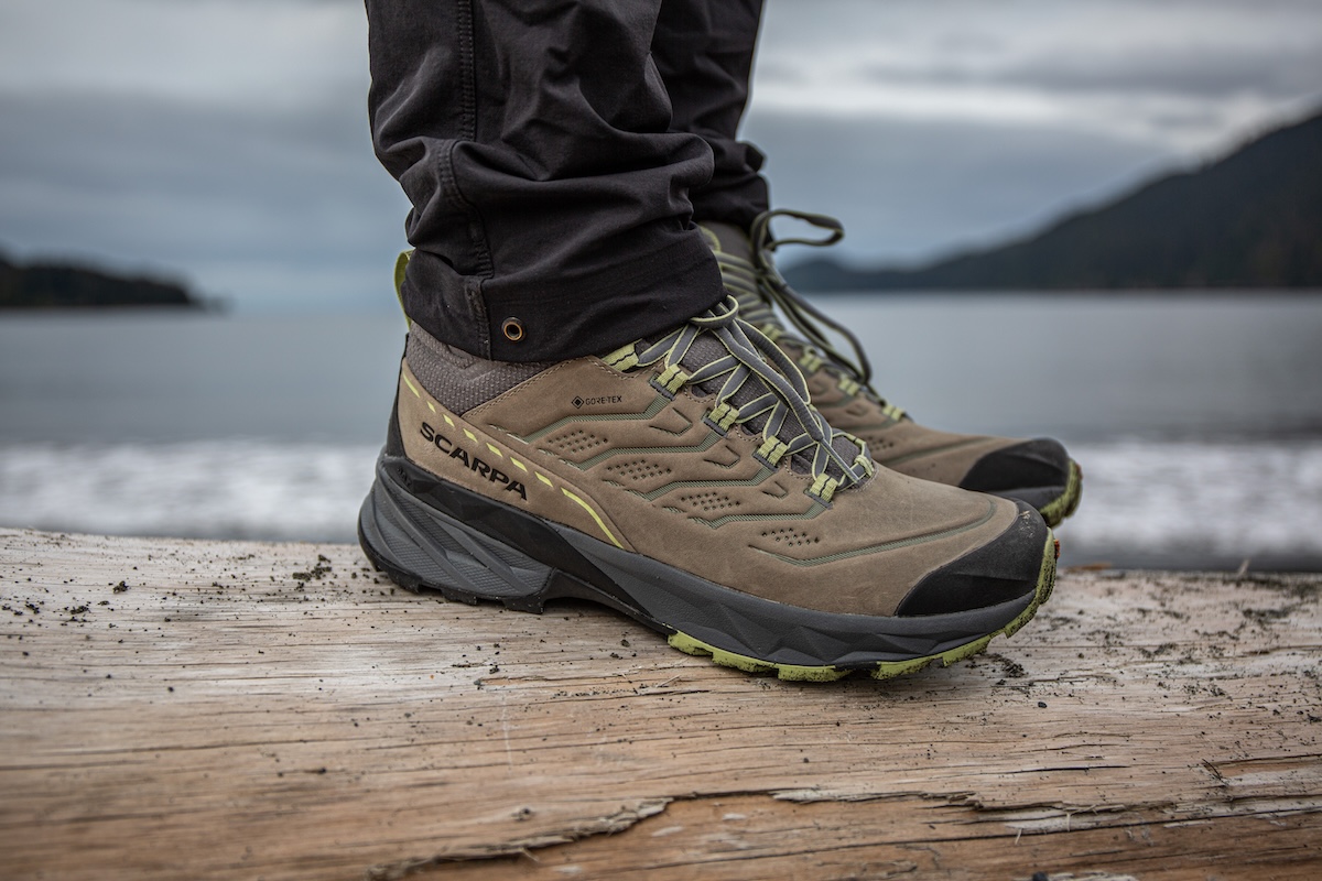 A closeup shot of boots with a lake in the background