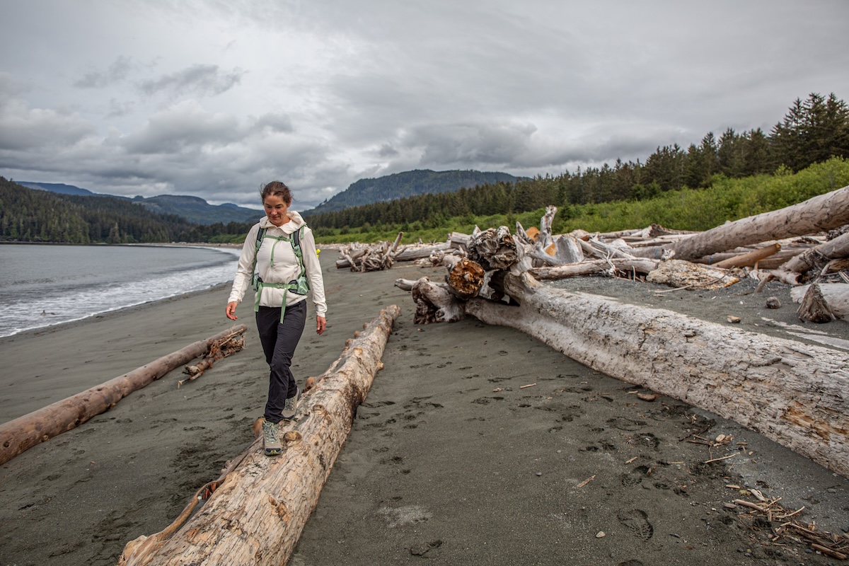 A woman walks on a beach in lightweight hiking boots