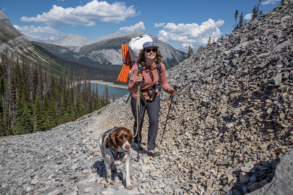 A woman hikes in Canada with a dog