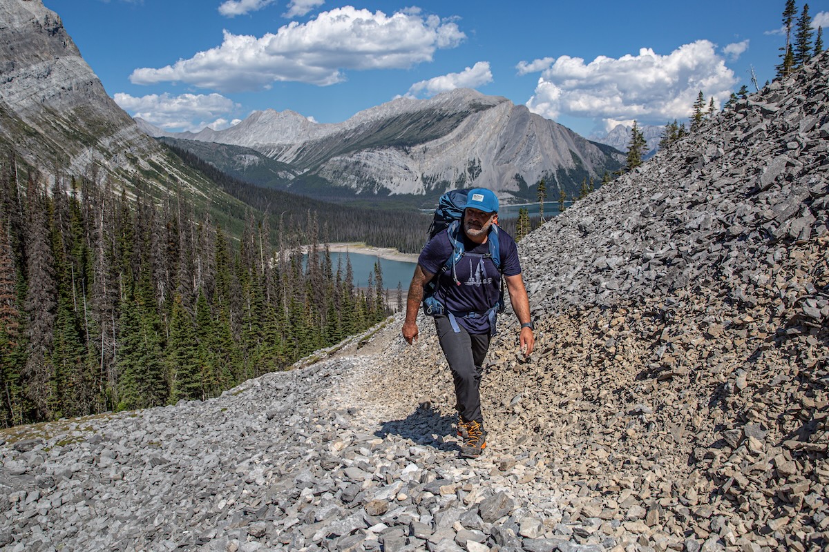 A hiker traverses a rocky path in the mountains.