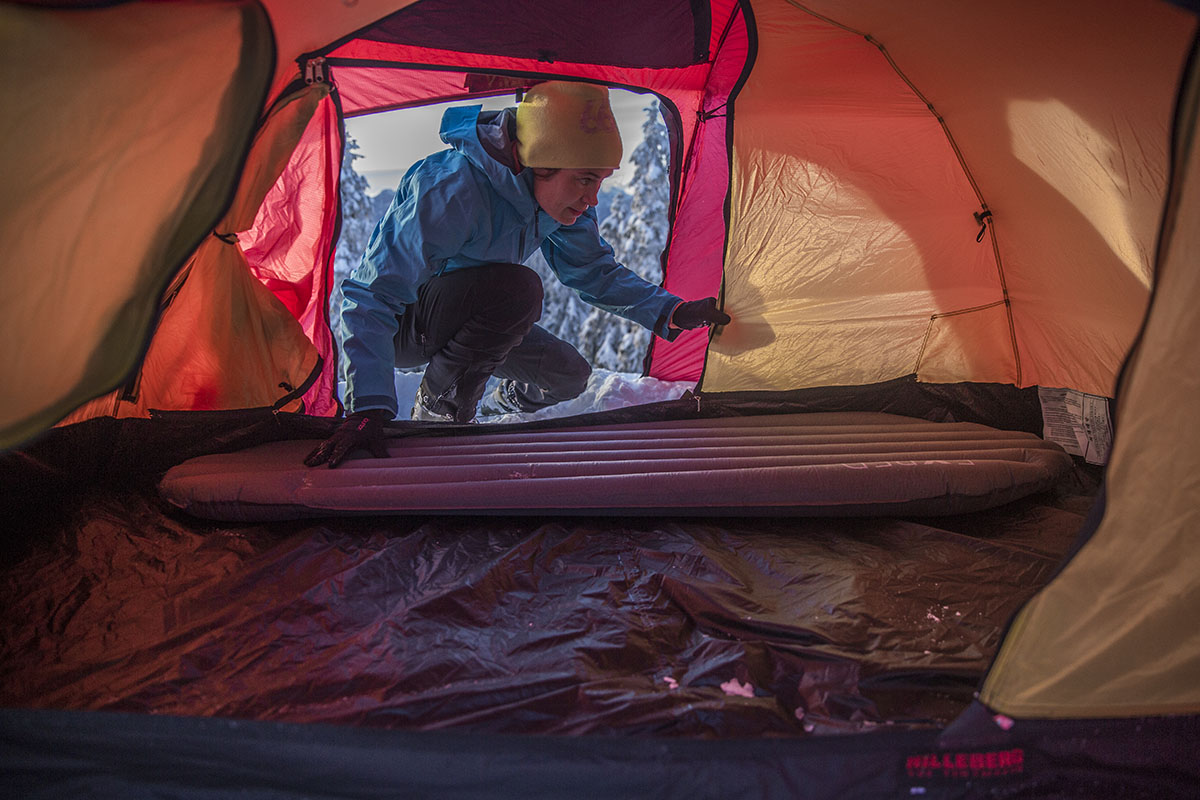 A woman putting a pad in the Hilleberg Allak