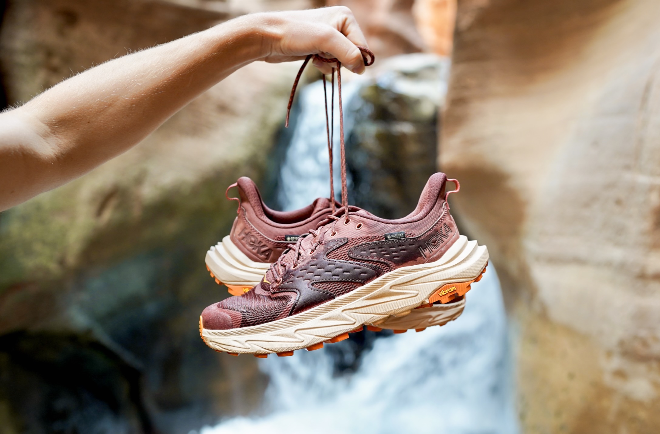 Holding a pair of waterproof hiking shoes by their laces