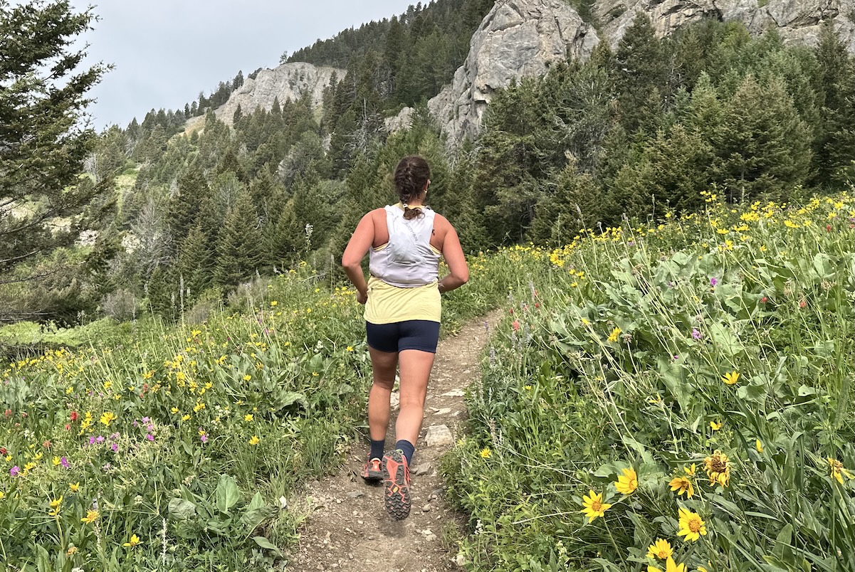 a woman running up a trail 