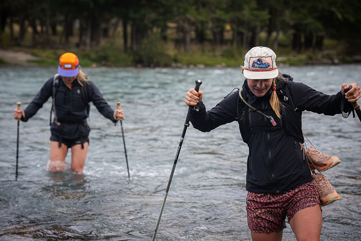 Two women crossing a deep river with waterproof hiking shoes