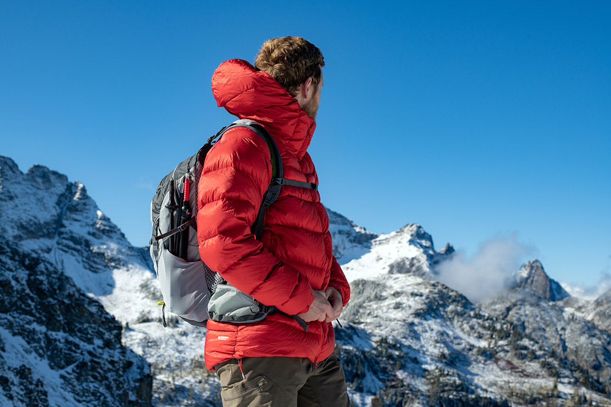 On a high mountain trail, a hiker looks out over the mountain horizon.