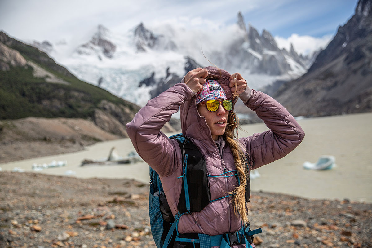 A woman pulling on a hood of a synthetic jacket