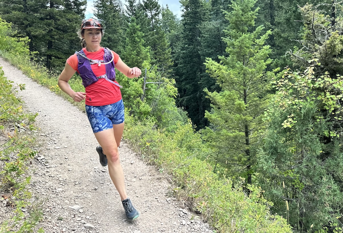 a woman trail running in the trees