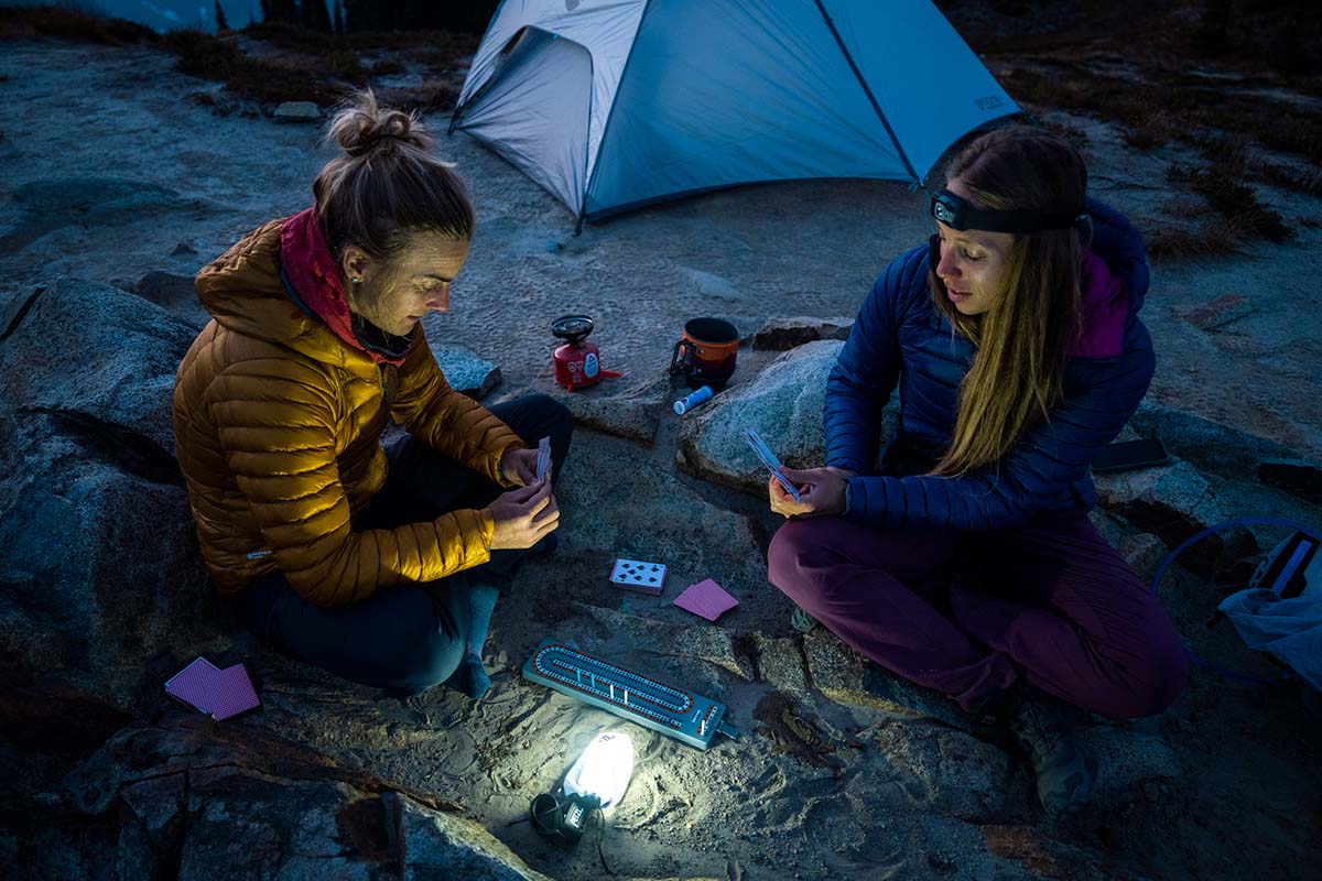 Two campers playing cards near a tent