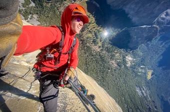 A man rock climbing in Yosemite with a walkie talkie