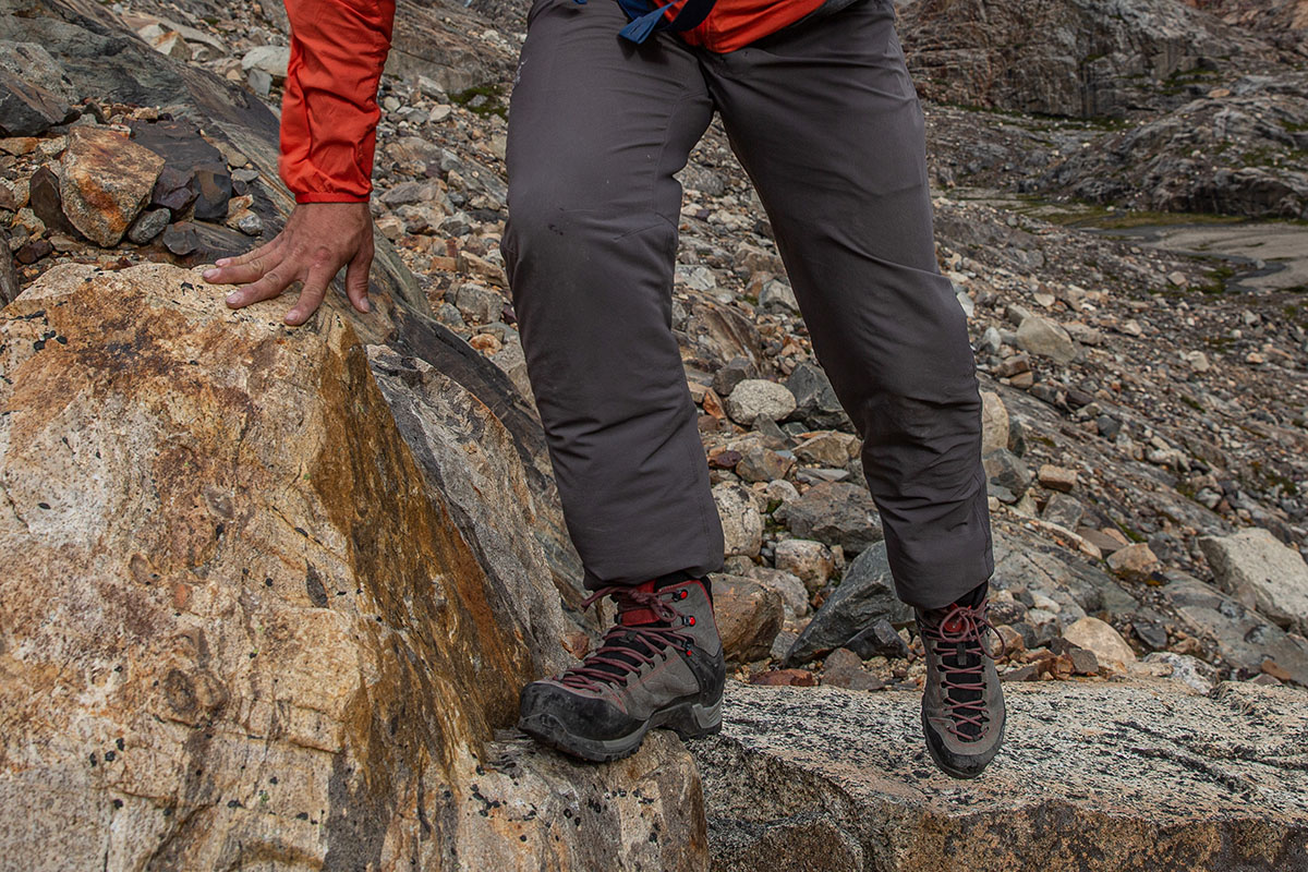 A man stepping over big rocks in the Salewa MTN Trainer Mid GTX hiking boot