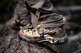 A closeup of the grip of the Salomon Quest 4 GTX hiking boot on a wet log