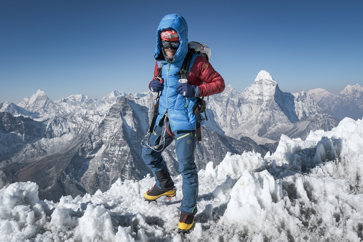 A mountaineer shown on the top of an icy peak in Nepal